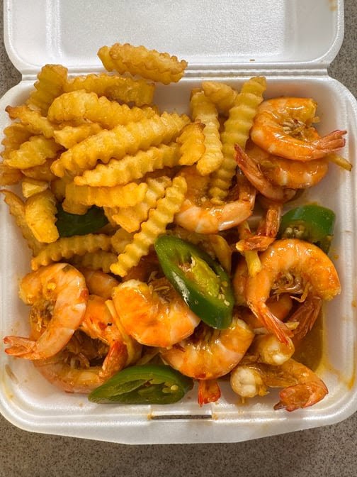 Takeout boxes packed with shrimp and sides.